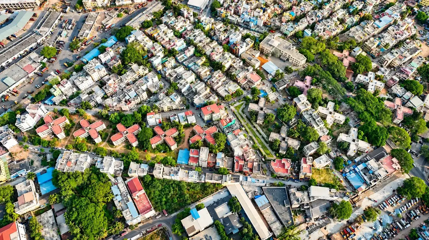 Aerial view of a dense Bengaluru residential neighbourhood with homes, apartment blocks and trees